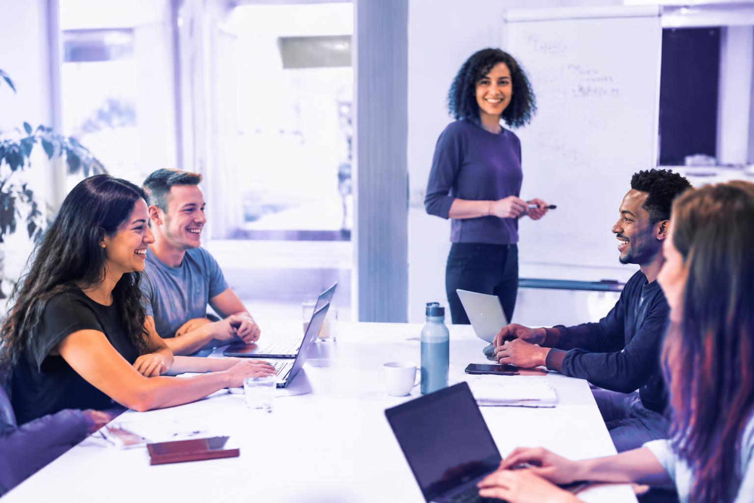 Equipe corporativa sorrindo em sala de reunião durante capacitação em IA